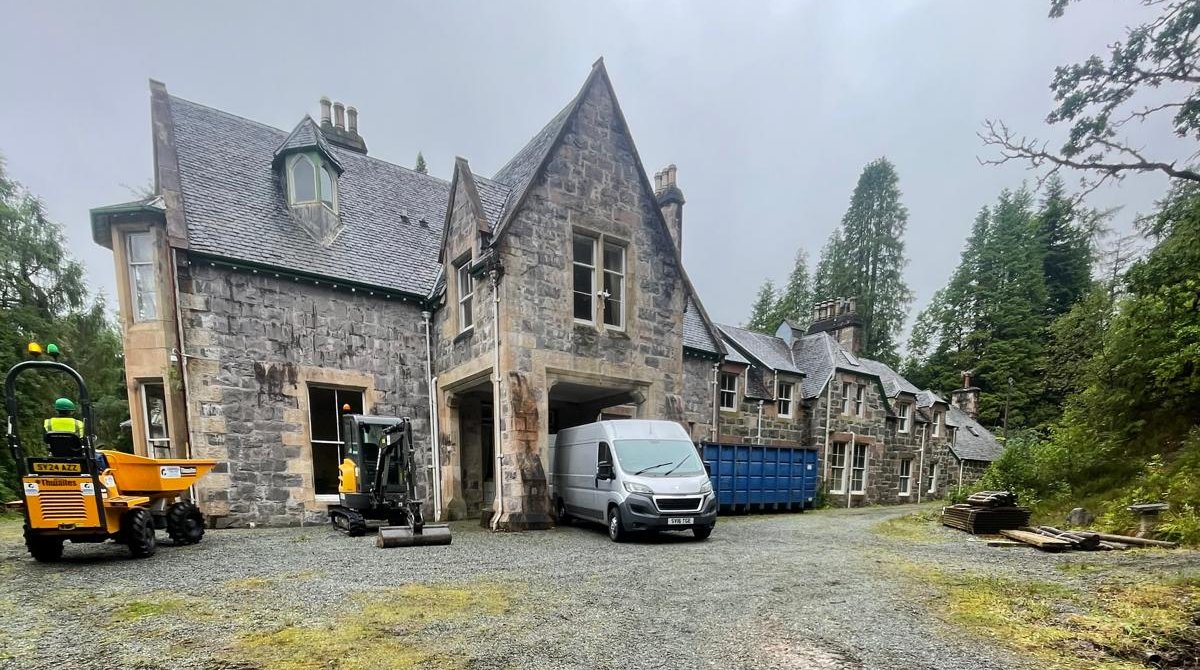 Stone Highland lodge under renovation with plant on site